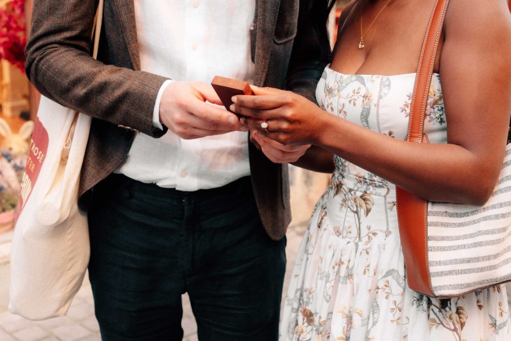 Engagement photo of a couple exchanging rings